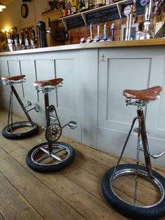 two old fashioned bicycles are sitting on the floor in front of some bar stools