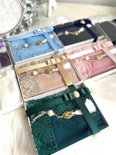 six different colored boxes with pearls and laces on the inside one box has a necklace in it