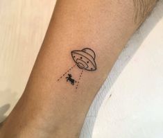 a small tattoo on the arm of a person with an saturn balloon in the sky