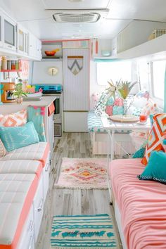 the inside of a camper with couches, tables and rugs on the floor