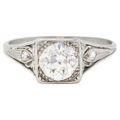 an antique style diamond ring with filigrees on the shoulders and sides, set in