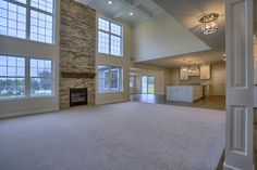 an empty living room with high ceilings and large windows