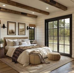 a large bed sitting inside of a bedroom on top of a wooden floor next to a window