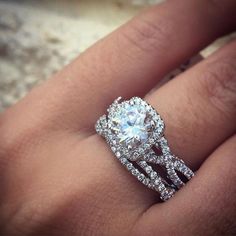 a woman's hand with a diamond ring on top of her finger and the engagement band