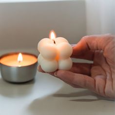 a person holding a lit candle in their hand