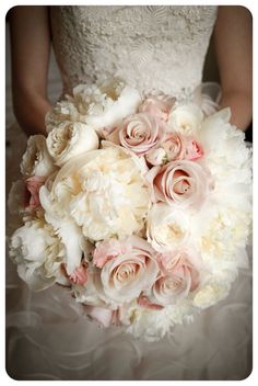 a bride holding a bouquet of white and pink flowers