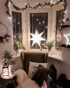 a living room decorated for christmas with lights and decorations on the window sill above