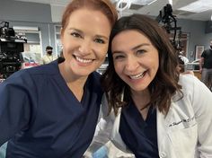 two women in scrubs smile for the camera