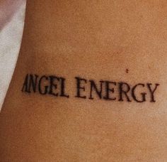 an angel energy tattoo on the back of a woman's leg with words written in black ink