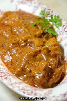 a close up of a plate of food with meat and gravy on it