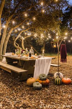 a picnic table set up with lights and pumpkins