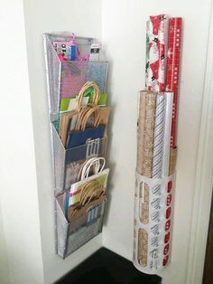 a stack of books and magazines hanging on a wall next to a door with wrapping paper