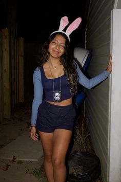 a woman in bunny ears standing next to a wall