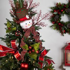 a decorated christmas tree with a snowman on top