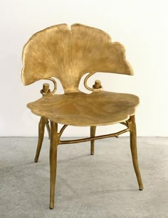 a wooden chair sitting on top of a carpeted floor next to a white wall