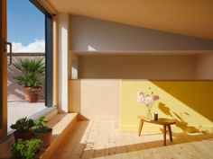 an empty room with a chair and potted plants