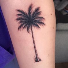 a small palm tree tattoo on the arm