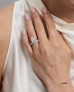 a woman wearing a diamond ring and white dress