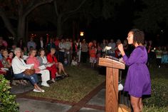 a woman standing at a podium in front of an audience