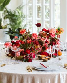 the table is set with flowers and wine glasses