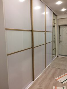 an empty room with white walls and gold trimmings on the doors, in front of a mirror