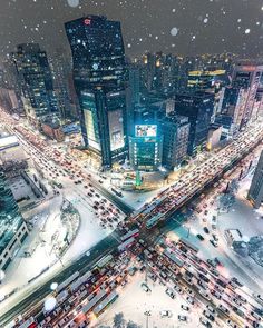 an aerial view of a city at night in the snow