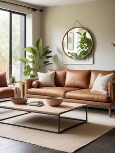 a living room with couches, tables and potted plants on the table in front of large windows