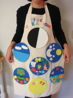 a woman wearing an apron made to look like the moon and stars is standing in front of a white wall