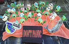 a bunch of cake pops sitting on top of a pink towel with stickers that say don't panic