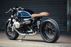 a black and white motorcycle parked in front of a garage door with no one around it