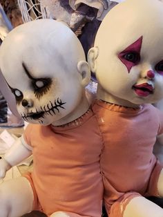 two creepy dolls sitting next to each other