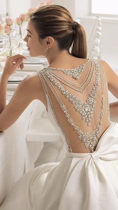 the back of a woman's wedding dress, with pearls and crystals on it