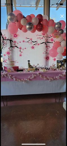 the table is decorated with balloons and flowers