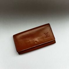 Louis Vuitton Leather Key Holder Featuring Gold-Tone Hardware With Button Clasp Closure And Four Rings. Please Note That Hardware Has Slight Scratches Throughout And There Is Discoloration On The Back (Easy Fix). Measurements: 10.5cm Length X 5.5cm Height Color Is Saddle Brown. Luxury Cognac Wallets For Travel, Luxury Cognac Travel Wallets, Leather Key Holder, Louis Vuitton Brown, Saddle Brown, Leather Key, Key Holder, Louis Vuitton Bag, Saddle