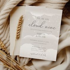 there is a wedding card and some wheat on the bed with white blankets around it