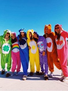 a group of people standing next to each other in animal onesuits on the beach