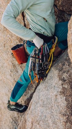 a woman climbing up the side of a mountain