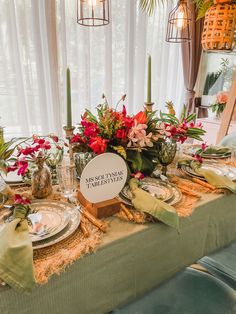 the table is set with flowers and place settings