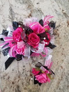 a pink and black corsage on a marble surface