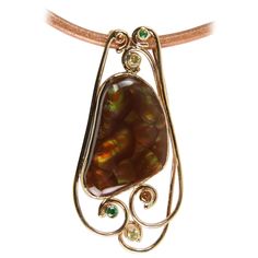 Stylish and Subtlety Beautiful Pendant Necklace boasts an Awesome Fire Agate Gem Stone and enhanced with Sapphire and Tsavorite Gem Stones mounted in a Hand crafted 18K yellow Gold setting. The Sterling Silver hand crafted back plate is marked, Artist Signed and dated: Fire Agate. Sapphire. Tsavorite. 2007. 18K. 14K. Sterling. RICK DUBER. Pendant measures 2.25” x 1.25” and is suspended on an 18” long Leather Cord Necklace with a Sterling Silver clasp. Classic and Timeless…Family Heirloom Quality Beautiful Pendant Necklace, Sapphire Necklace Pendants, Leather Cord Necklace, Leather Corded Necklace, Fire Agate, Sapphire Pendant, Yellow Gold Setting, Cameo Pendant, Gem Stones