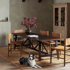 a dog laying on the floor in front of a dining room table and chair set