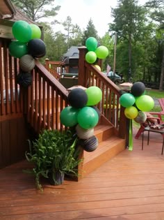 some green and black balloons are on the porch