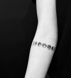 a black and white photo of a woman's arm with the word moon tattooed on it