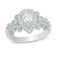 a white gold ring with an oval cut diamond surrounded by smaller round diamonds and pave set shoulders