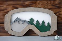 a snowboarder's goggles with trees and mountains cut out of it