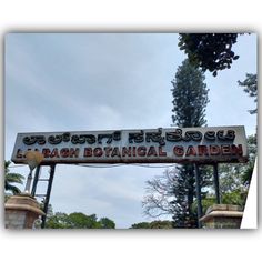 a sign that is hanging from the side of a pole with trees in the background