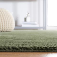 a green rug on top of a wooden floor