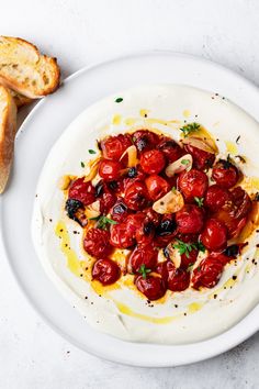 a white plate topped with tomatoes and bread