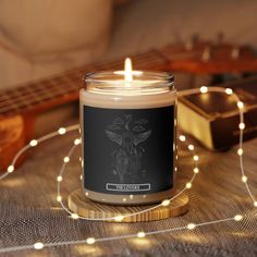 a candle sitting on top of a table next to a guitar