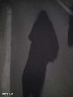 the shadow of a person standing in front of a wall